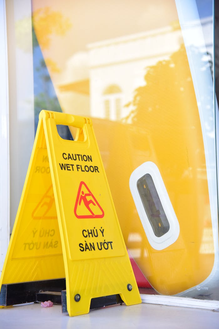 Yellow caution wet floor sign indoors against a colorful surfboard display.